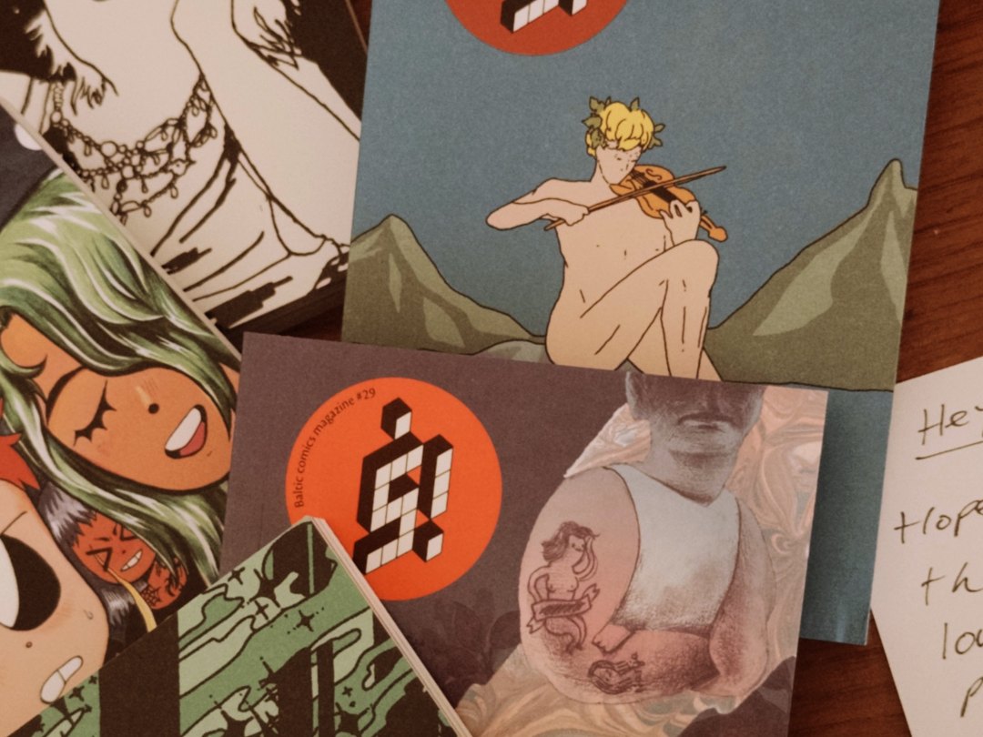 ラトビアの出版社 kuš! から届いたコミック誌が机に広がっている